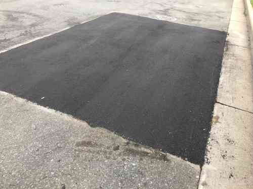freshly repaired asphalt over old asphalt